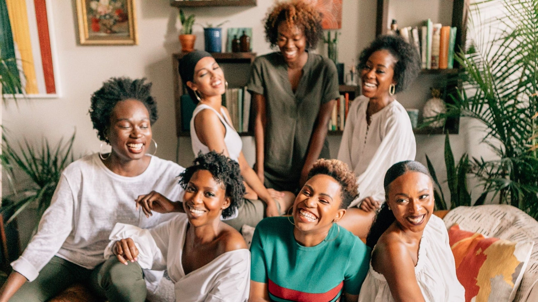 Group of women sitting together on a couch in a cozy living room.